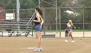 Coach shows 2 female athletes how to properly tend to a big bat